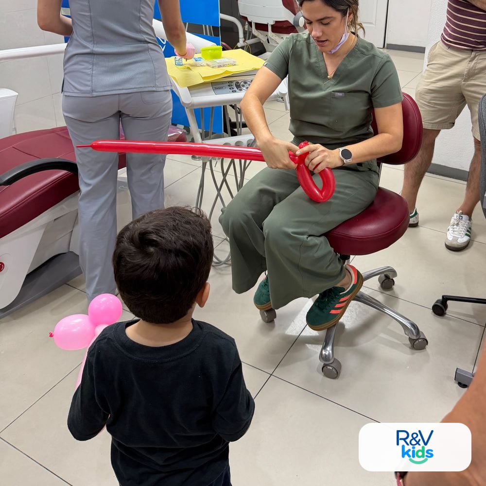 La odontopediatra de R&V Kids haciéndole un globo a un niño antes de la cita, atención dental infantil para Grecia